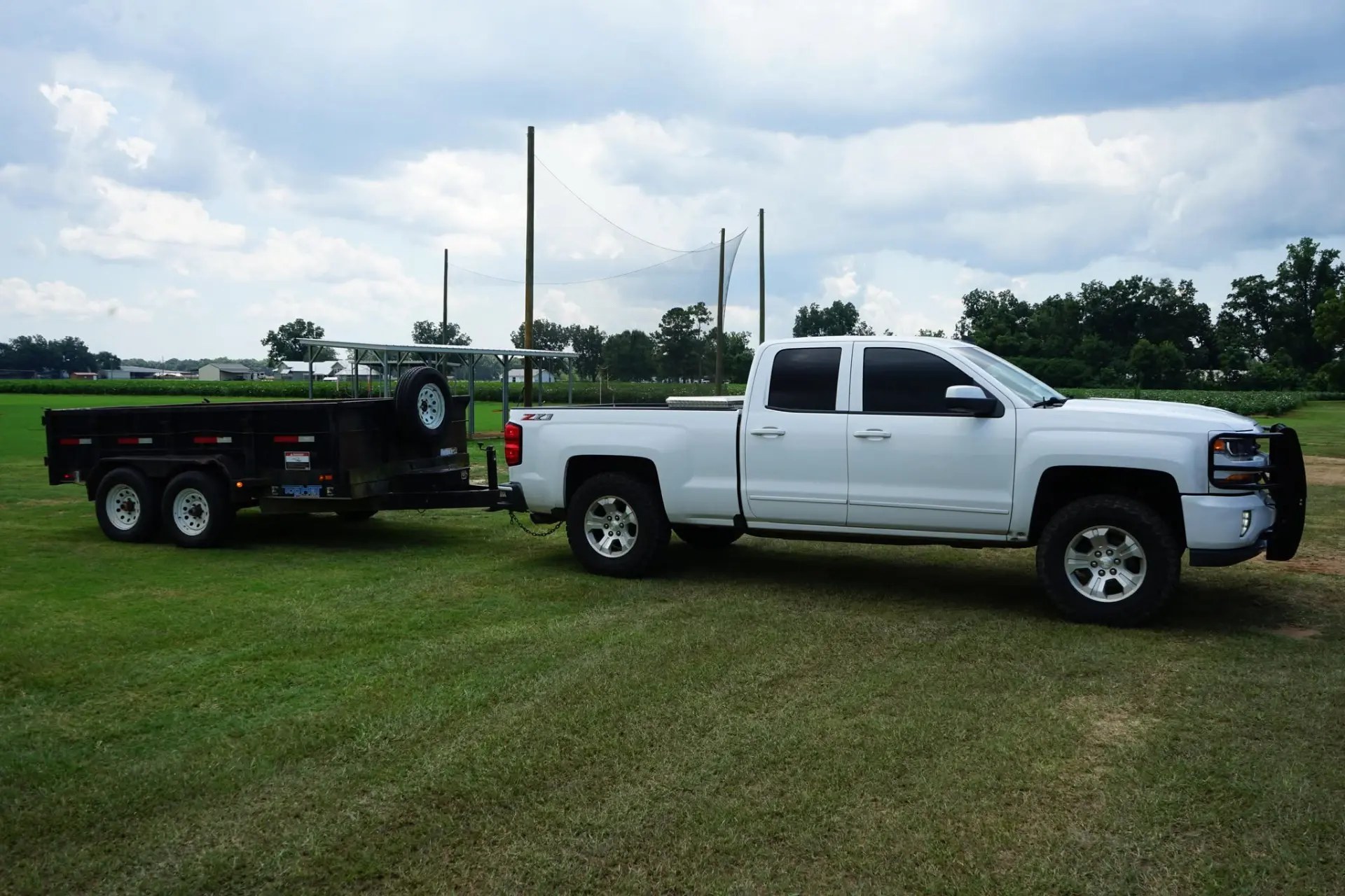 White pickup truck with a dump trailer used for junk hauling in Tuscaloosa County